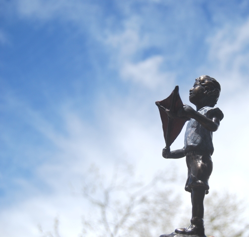a boy and his kite a bronze sculpture by Joel Walker
